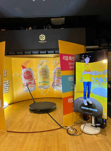 행사장에 설치된 360도 촬영 키오스크 정면 — 회전 촬영대와 세로형 키오스크 화면
